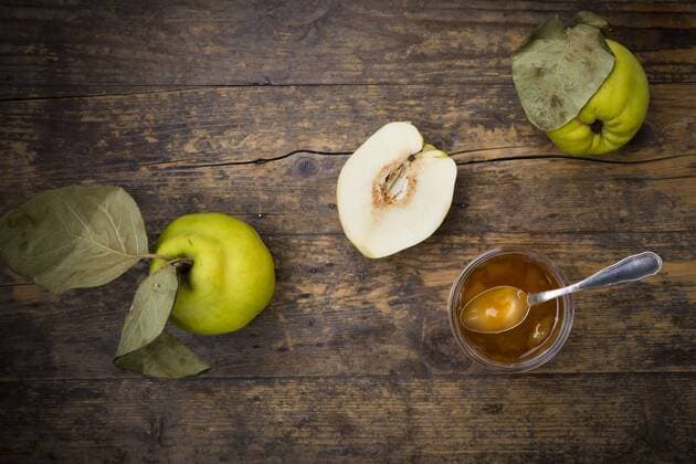 Quinces and a glass of quince jam on wood  LVF003985