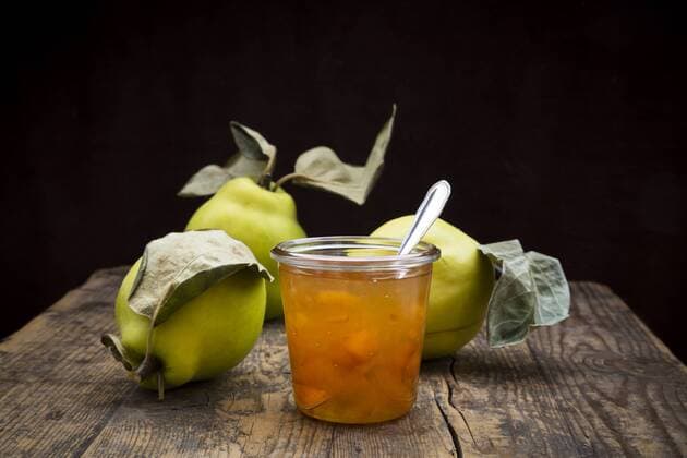 Quinces and a glass of quince jam on wood  LVF003986