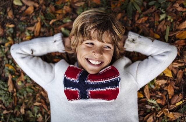 Portrait of smiling blond boy wearing pullover with Norwegian Flag  MGOF000874