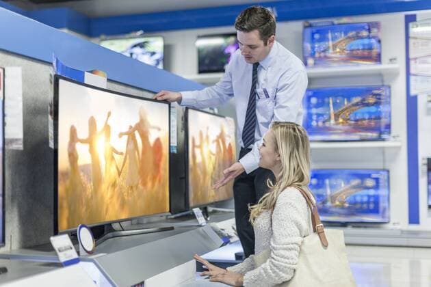 Model Released: Beratung im Elektronikfachgeschäft Shop assistant showing flatscreen TV to customer model released Symbolfoto property released  ZEF007091