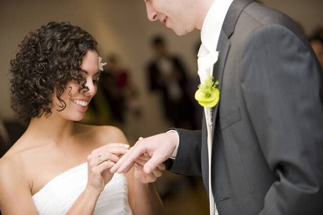 Hochzeit, Braut steckt dem Braeutigam den Ring an den Finger married in a civil ceremony, bride sticking the wedding ring at the finger of her husband BLWS241866