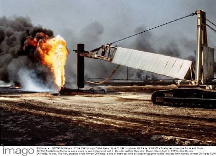 April 7, 1991 - Ahman Oil Fields, KUWAIT - Firefighters from the Boots and Coots Oil Well Firefighting Company use a crane to cap a blazing oil well in the aftermath of Operation Desert Storm April 7, 1991 in the Ahman Oil Fields, Kuwait. The well, situated in the Ahman Oil Fields, is one of many set afire by Iraqi forces prior to their retreat from Kuwait. Ahman Oil Fields KUWAIT - ZUMAp138