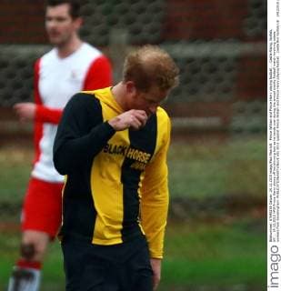 Prince William and Prince Harry playing football . . Castle Rising, Norfolk, UK . . 24.12.2015 HRH Prince Harry shows off his thinning hair as he bends over during the annual charity football match involving estate workers from Sandringham. 