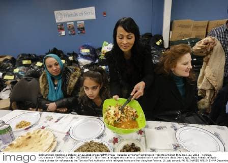Kanada: syrische Flüchtlinge in Toronto erhalten Hilfe Dec. 27, 2015 - Toronto, ON, Canada - TORONTO, ON - DECEMBER 27: Tina Tran, a refugee who came to Canada from North Vietnam thirty years ago, helps Friends of Syria host a dinner for refugees at the Toronto Port Authority while refugees Aisha and her daughter Fatima, 10, get served. MORE IMAGES ARE IN EMMA December 27, 2015. Toronto Canada  - ZUMAt14_