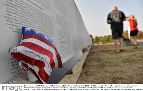 20 Jahre Anschläge vom 11. September: Gedenkkultur in den USA September 11, 2013 - East Meadow, New York, U.S. - A patriotic red white and blue balloon has messages written on it to William V. Steckman (Pop-Pop) of West Hempstead, who worked in the North Tower of Twin Towers, and died 9 11 2001. A man and woman were walking along the Global War on Terror Wall of Remembrance a traveling memorial on display in New York for the first time, at Eisenhower Park on the 12th Anniversary of the terrorist attacks of 9 11. The unique 94 feet long by 6 feet high wall has, on one side, almost 11,000 names of those lost on September 11th 2001, along with heroes and veterans who lost their lives defending freedom of Americans over past 30 years. - ZUMAp115