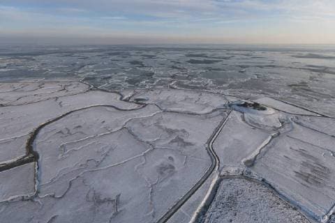 Aerial view of Neuwarft on Hallig Island Nordstrandischmoor, in winter with snow and ice on the Wadden Sea, Schleswig-Holstein National Park, North Sea, Germany February 2012  1404159 KerstinxxHinze