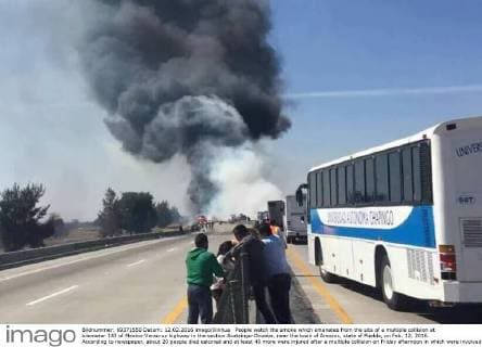People watch the smoke which emanates from the site of a multiple collision at kilometer 143 of Mexico-Veracruz highway in the section Acatzingo-Orizaba, near the town of Amozoc, state of Puebla, on Feb. 12, 2016. According to newspaper, about 20 people died calcined and at least 40 more were injured after a multiple collision on Friday afternoon in which were involved more than 10 vehicles that caught fire. ) (jp) BETTER QUALITY AVAILABLE MEXICO-PUEBLA-ACCIDENT-COLLISION VERSIONES 