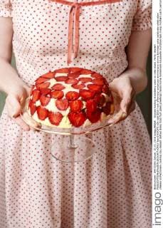 Woman holding strawberry cake on cake stand. Party dessert  bew1A3A2F5