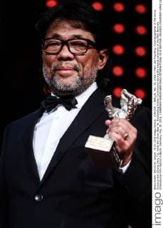(160220) -- BERLIN, Feb. 20, 2016 -- Mark Lee Ping-Bing, Cinematographer of the movie Crosscurrent (Chang Jiang Tu), holds the Silver Bear for Outstanding Artistic Contribution during the awards ceremony of the 66th Berlinale International Film Festival in Berlin, Germany, Feb. 20, 2016. ) GERMANY-BERLIN-BERLINALE INTERNATIONAL FILM FESTIVAL-AWARDS CEREMONY-MARK LEE ZhangxFan 