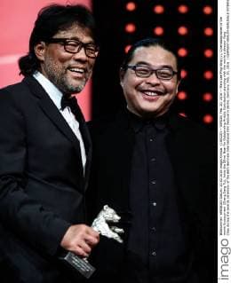 (160220) -- BERLIN, Feb. 20, 2016 -- Mark Lee Ping-Bing (L), Cinematographer of the movie Crosscurrent (Chang Jiang Tu), holds the Silver Bear for Outstanding Artistic Contribution standing with the movie s director Yang Chao during the awards ceremony of the 66th Berlinale International Film Festival in Berlin, Germany, Feb. 20, 2016. ) GERMANY-BERLIN-BERLINALE INTERNATIONAL FILM FESTIVAL-AWARDS CEREMONY-MARK LEE ZhangxFan 