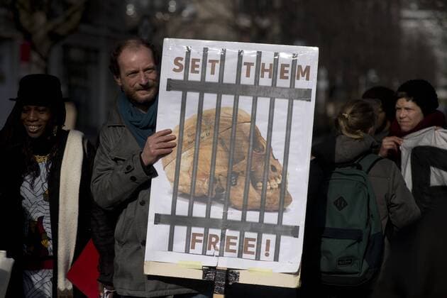 Gedenkmarsch Kolonialgeschichte DEU, Deutschland, Germany, Berlin, 27.02.2016 Demonstranten mit Plakat Voelkermord verjaehrt nicht und Set them Free beim 10. Gedenkmarsch zur Erinnerung an die afrikanischen Opfer von Versklavung, Kolonialismus und rassistischer Gewalt vom Komitee fuer ein afrikanisches Denkmal in Berlin und afrikanischer Vereine in Berlin. Dieser Gedenkmarsch wurde ins Leben gerufen, um der Forderung nach Anerkennung der Verbrechen gegen Schwarze Menschen und Menschen afrikanischer Herkunft Nachdruck zu verleihen. Anlass ist die Berliner Afrika-Konferenz von 1884 - 1885, auf der Afrika vor 130 Jahren unter den europaeischen Kolonialmaechten aufgeteilt wurde. Mehr als 30 Millionen Afrikanerinnen und Afrikaner wurden Opfer von Versklavung und kolonialen Verbrechen gegen die Menschlichkeit. Die von Deutschland an den Herero und Nama begangenen Voelkermorde in Namibia und di