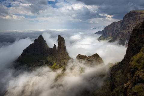 Drakensberg Escarpment, the pinnacles known as the pyramid and the column can be seen protruding from the mist. KwaZulu-Natal, South Africa. November 2012.  1484249 HougaardxMalan