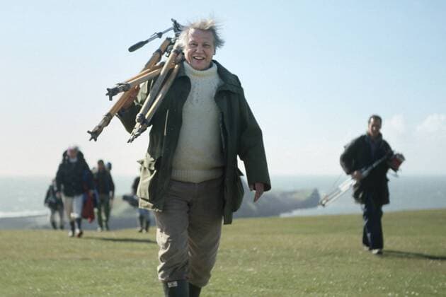 IMAGO ICONS: Sir David Attenborough David Attenborough carrying tripod back from a shoot on the Worm s Heads, on production for The Trials of Life. Gower Peninsula, Wales, UK, 1998. Small reproduction only.  1488203 NickxUpton
