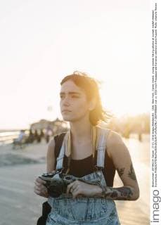 IMAGO Creative: Neue Aussichten USA, New York, Coney Island, young woman taking photos at sunset model released Symbolfoto  GIOF000669