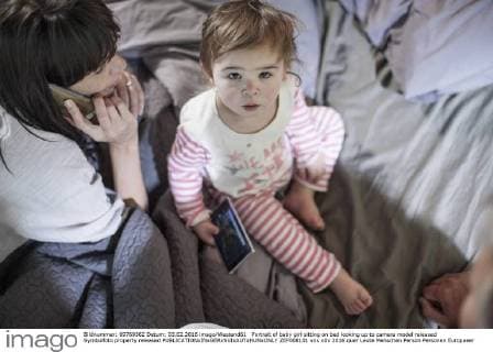 Portrait of baby girl sitting on bed looking up to camera model released Symbolfoto property released  ZEF008101