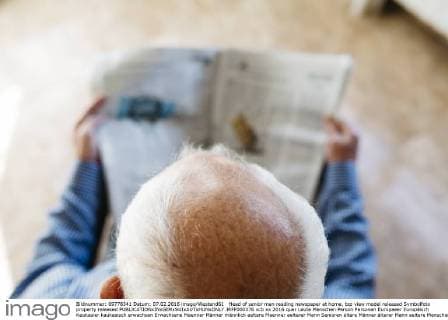 Head of senior man reading newspaper at home, top view model released Symbolfoto property released  JRFF000376