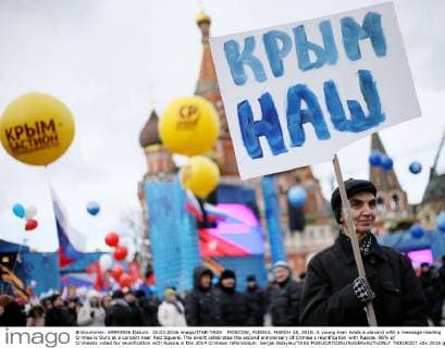MOSCOW, RUSSIA. MARCH 18, 2016. A young man holds a placard with a message reading Crimea is Ours at a concert near Red Square. The event celebrates the second anniversary of Crimea s reunification with Russia. 96% of Crimeans voted for reunification with Russia in the 2014 Crimean referendum. Sergei Bobylev TASS  TS019DD7