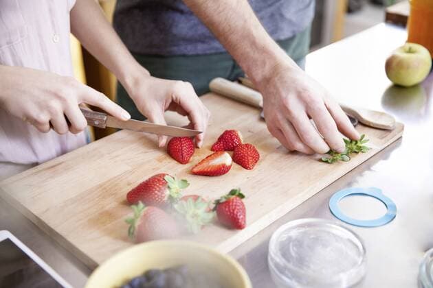 Couple cutting strawberries in kitchen model released Symbolfoto property released  FMKF002348