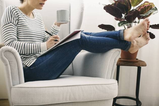 Woman sitting in armchair writing on notepad model released Symbolfoto property released  EBSF001245