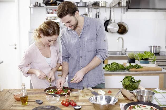 Couple preparing pizza in kitchen model released Symbolfoto property released  FMKF002346