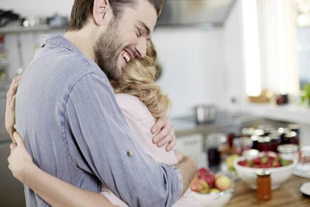 Happy couple hugging in kitchen model released Symbolfoto property released  FMKF002405