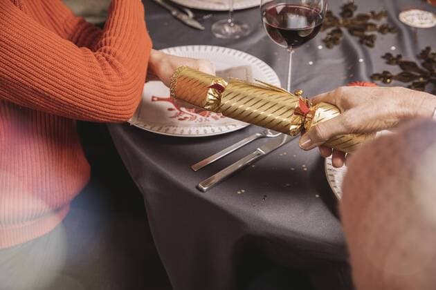 Two female hands pulling at ends of a Christmas cracker model released Symbolfoto property released  MFF002834
