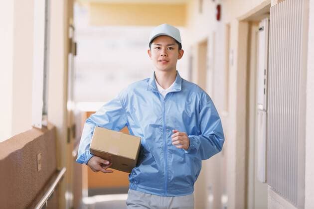 Young Japanese delivery man with box  (jjig004131)