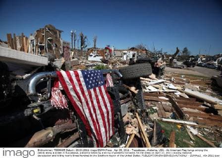 IMAGO Nature: Unsere Erde, Klimawandel, Wirbelstürme Apr 29, 2011 - Tuscaloosa , Alabama, USA - An American Flag hangs among the debris along a street in Tuscaloosa, Alabama following a string of powerful tornados hit the areas on April 27, 2011 causing massive devastation and killing nearly three hundred in the Southern region of the United States. - ZUMAcz2_