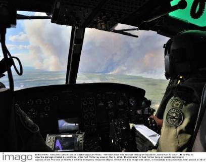Members from 408 Tactical Helicopter Squadron, Edmonton fly a CH-146 Griffon to view the damage created by wild fires in the Fort McMurray area on May 5, 2016. The Canadian Armed Forces have air assets deployed in support of the Province of Alberta s wildfire emergency response efforts. At the time this image was taken, a mandatory evacuation had been placed on all of Fort McMurray - the largest evacuation on record in Canada. The fire had burned through nearly 77 square kilometers, razing neighborhoods across the city.  WAX2016050628 MCplxVanPutten