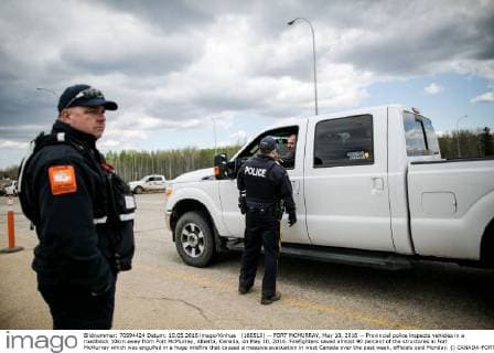 (160510) -- FORT MCMURRAY, May 10, 2016 -- Provincial police inspects vehicles in a roadblock 10km away from Fort McMurray, Alberta, Canada, on May 10, 2016. Firefighters saved almost 90 percent of the structures in Fort McMurray which was engulfed in a huge wildfire that caused a massive evacuation in west Canada over the past week, officials said Monday. () CANADA-FORT MCMURRAY-WILDFIRE-AFTERMATH AmruxSalahuddien 
