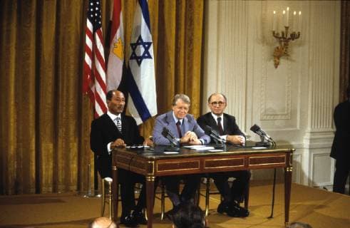 Jan. 2, 2011 - Washington, District of Columbia, United States of America - United States President Jimmy Carter, center, makes remarks as President Anwar Sadat of Egypt, left, and Prime Minister Menahem Begin of Israel, right, look on prior to signing the Camp David Accords at a ceremony in the East Room of the White House in Washington, D.C. on September 17, 1978.. - ZUMAs152