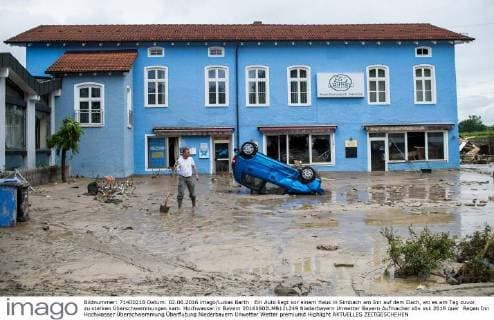 Ein Auto liegt vor einem Haus in Simbach am Inn auf dem Dach, wo es am Tag zuvor zu starken Überschwemmungen kam. Hochwasser in Bayern 20160602LMB121249