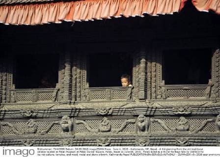 June 4, 2016 - Kathmandu, NP, Nepal - A Kid glancing from the old traditional window located at Patan Museum at Patan Durbar Square, Patan, Nepal on June 04, 2016.. Patan listed as a World Heritage Site by UNESCO for its rich culture, temples, and wood, metal and stone artwork. Kathmandu Nepal  - ZUMAn230