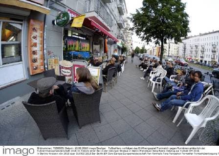 Fußballfans verfolgen das Eröffnungsspiel Frankreich gegen Rumänien anlässlich der Fußball-Europameisterschaft 2016 im Freisitz einer Bar in der Danziger Strasse in Berlin-Prenzlauer Berg Public Viewing zur Fußball EM 2016 in Berlins Kneipen