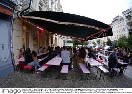 Fußballfans verfolgen das Eröffnungsspiel Frankreich gegen Rumänien anlässlich der Fußball-Europameisterschaft 2016 im Freisitz einer Bar in der Oderberger Strasse in Berlin-Prenzlauer Berg Public Viewing zur Fußball EM 2016 in Berlins Kneipen