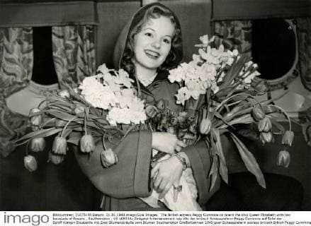 The British actress Peggy Cummins on board the ship Queen Elizabeth with two bouquets of flowers , Southampton , UK x08334x 