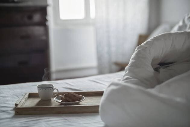 Wooden tray with cup of steaming coffee and biscuits on bed property released  RIBF000401