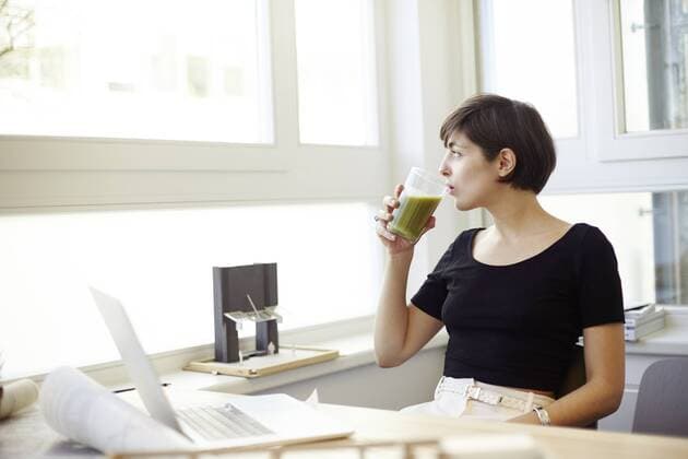 Portrait of woman drinking green smoothie in the office model released Symbolfoto property released  TSFF000042