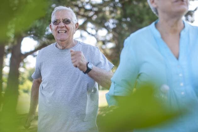 Senior man with woman running in forest model released Symbolfoto  ZEF008713