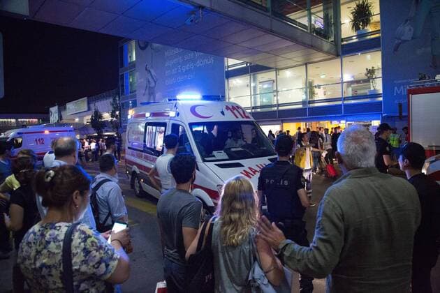 Turks gathers while forensic police work the explosion site at Ataturk Airport after two explosions followed by gunfire hit Turkey s biggest airport, killing dozens and injuring many on June 28, 2016, in Istanbul. All flights at Istanbul s Ataturk international airport were suspended, Turkish television stations reported.  TRK2016062904 LAURANCExCAMERON