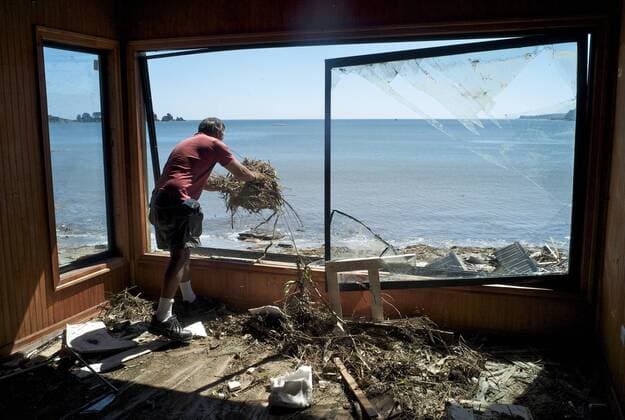 Mar 08, 2010 - Dichato, Concepcion, Chile - Alojo Valderrama, 58, removes debris from his beachfront home. A tsunami created by an 8.8-magnitude earthquake destroyed the house - ZUMAf76_