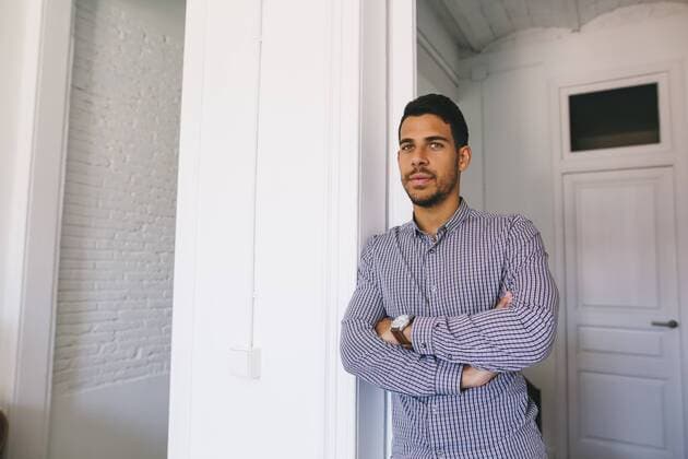 Young man in office leaning in door with arms crossed model released Symbolfoto property released  EBSF001479