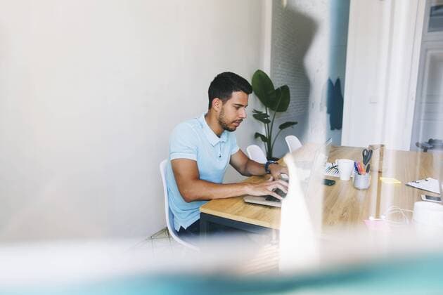 Young man working in office, using laptop model released Symbolfoto property released  EBSF001528
