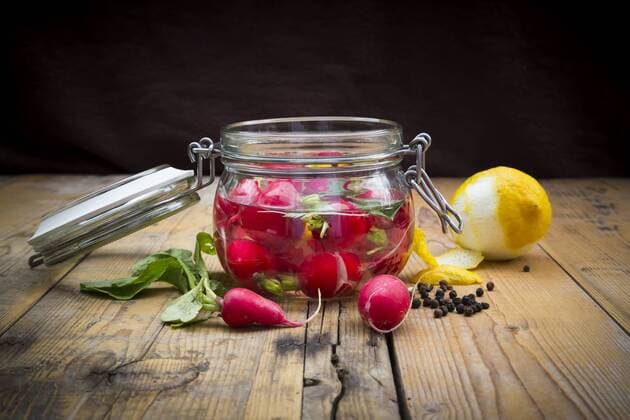Glass of pickled red radishes and ingredients on wood  LVF005047
