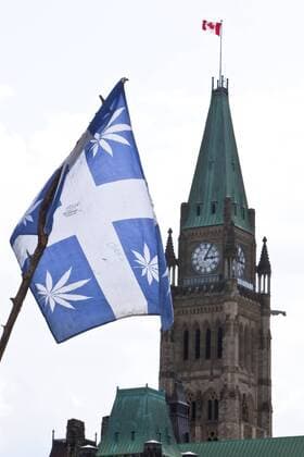 Apr. 20, 2010 - Ottawa, Ontario, Canada - 20 April 2010: A cannabis flag waves in the wind with the Peace Tower in the background during the 420 rally on Parliament Hill in Ottawa, Ontario, Canada. 420, 4:20 or 4 20 (pronounced four-twenty) refers to consumption of cannabis, and by extension, a way to identify oneself with cannabis drug subculture. Started by a group called the Waldos in 1971 because members would hang out by a wall after school in San Rafael, California. They would often meet at 4:20 pm by a statue of Louis Pasteur to search for a crop of cannabis they heard about but never found. In doing so they smoked plenty of marijuana while on their search. Mandatory - ZUMAse4_