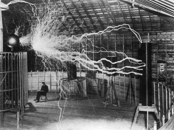 Inventor and scientist Nikola Tesla in his lab while his magnifying transmitter high voltage generator produces bolts of electricity. December 1899.  Copyright: JohnxParrot StocktrekxImages JPA101123M