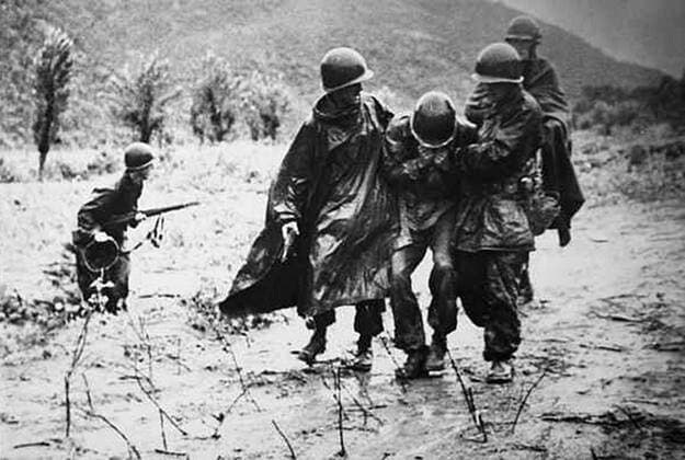 Korea-Krieg 1950-1953 - Aufnahmedaten geschätzt Photograph of Captain Emil Kapaun helping another soldier carry an exhausted troop off the battlefield early in the Korean War. Dated 1952 WHA  !ACHTUNG AUFNAHMEDATUM GESCHÄTZT! Copyright: WHA UnitedArchivesWHA_055_0625