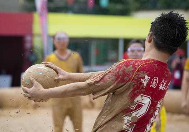 Schlammfußball in Peking BEIJING, CHINA - AUGUST 13: A player handles the ball during the first station match of 2016 Swamp Soccer China tournament at Yuetan Park on August 13, 2016 in Beijing, China. Different from former years matches in China, there were four teams composed entirely of women this year. The Swamp Soccer World Cup features a team of extreme football players that play in bogs or swamps. This sport is said to have originated in Finland, with the aim of helping athletes and soldiers exercise, due to the physical demands of the sport.  CFP490208069