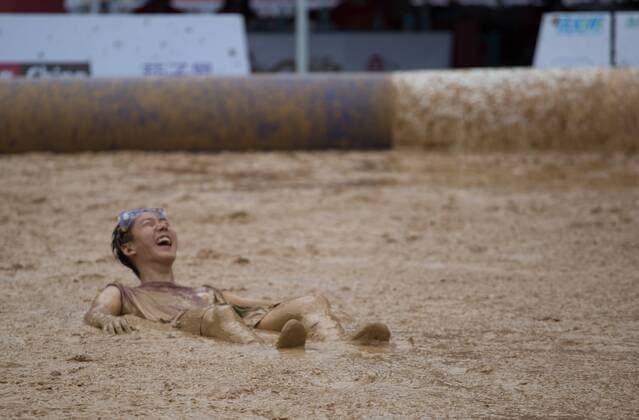 Schlammfußball in Peking BEIJING, CHINA - AUGUST 13: A player falls down in swamp during the first station match of 2016 Swamp Soccer China tournament at Yuetan Park on August 13, 2016 in Beijing, China. Different from former years matches in China, there were four teams composed entirely of women this year. The Swamp Soccer World Cup features a team of extreme football players that play in bogs or swamps. This sport is said to have originated in Finland, with the aim of helping athletes and soldiers exercise, due to the physical demands of the sport.  CFP490208071