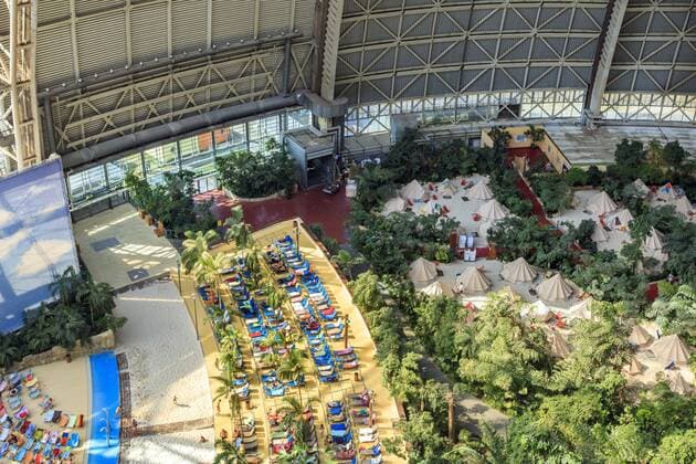 Südsee im Freizeitpark Tropical Islands DEU Brandenburg Brand - Briesen Â Voll im Trend: Tropenfeeling mitten in Deutschland. Das Tropical Islands Resort schuf, in der einst von Cargolifter AG gabauten rieseigen freitragenden Halle, einen Indoor-Regenwald und eine eine žSüdseeœ mit einem 200 Meter langem Sandstrand. Auch in diesen sehr wechselhaften Sommermanaten ist das Freizeitresort sehr gut besucht. Bei In- und Ausländischen Touristen liegt Deutschland voll im Trend. Die beheizten Ganzjahresbecken mit einer Wassertemperatur von rund 31 Grad Celsius festigen Tropical Islands Ruf als wetterunabhängiges Reiseziel. In dem etwa 66 000 Quadratmeter Resort herrschen 26 Grad. In diesem Jahr öffnete Tropical Islands AMAZONIA, der neue, ganzjährig geöffnete Außenbereich von Tropical Islands. Mittelfristig will das Unternehmen eines malayischen Investors weiterhin 60 Millionen